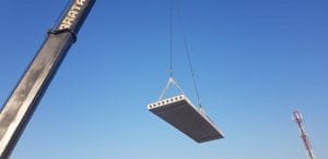 Hollow Core Concrete slap being lowered into place by a crane